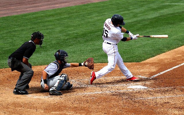 A baseball player hitting the ball on the field.